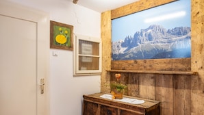 Ein rustikales Badezimmer mit einem Holzkabinent, einem gerahmten Gemälde von Bergen und einem kleinen Topfpflanzen.