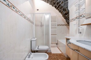 Une salle de bain avec une baignoire, des toilettes et une douche.
