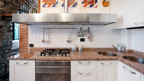 Una cocina con encimeras de granito, electrodomésticos de acero inoxidable y armarios blancos.