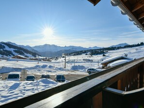 A snowy mountain landscape with a ski resort, including ski lifts and a parking area with several cars. - Cozy Studio Les Saisies - 2 Pers, 14m², piste view (Les Saisies)