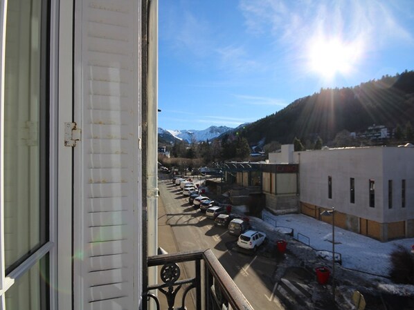 A view from a window overlooking a parking lot with cars, a building labeled "Casino," and a mountain range in the background.