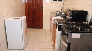 Eine kleine Küche mit Kühlschrank, Herd und Schränken.
