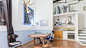 A compact kitchen with a dining table, chairs, and a microwave.