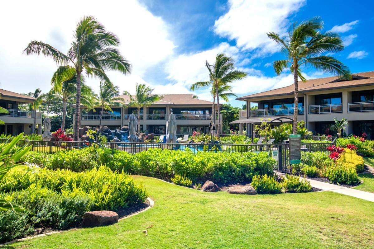 A resort with a swimming pool, palm trees, and a well-maintained garden.