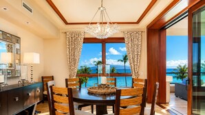 Comedor con vista al océano, un candelabro y una mesa de madera.