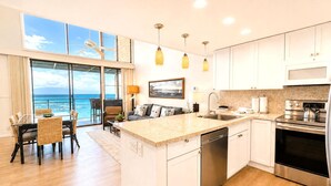 Una cocina moderna con una isla central, electrodomésticos de acero inoxidable y vistas al océano.