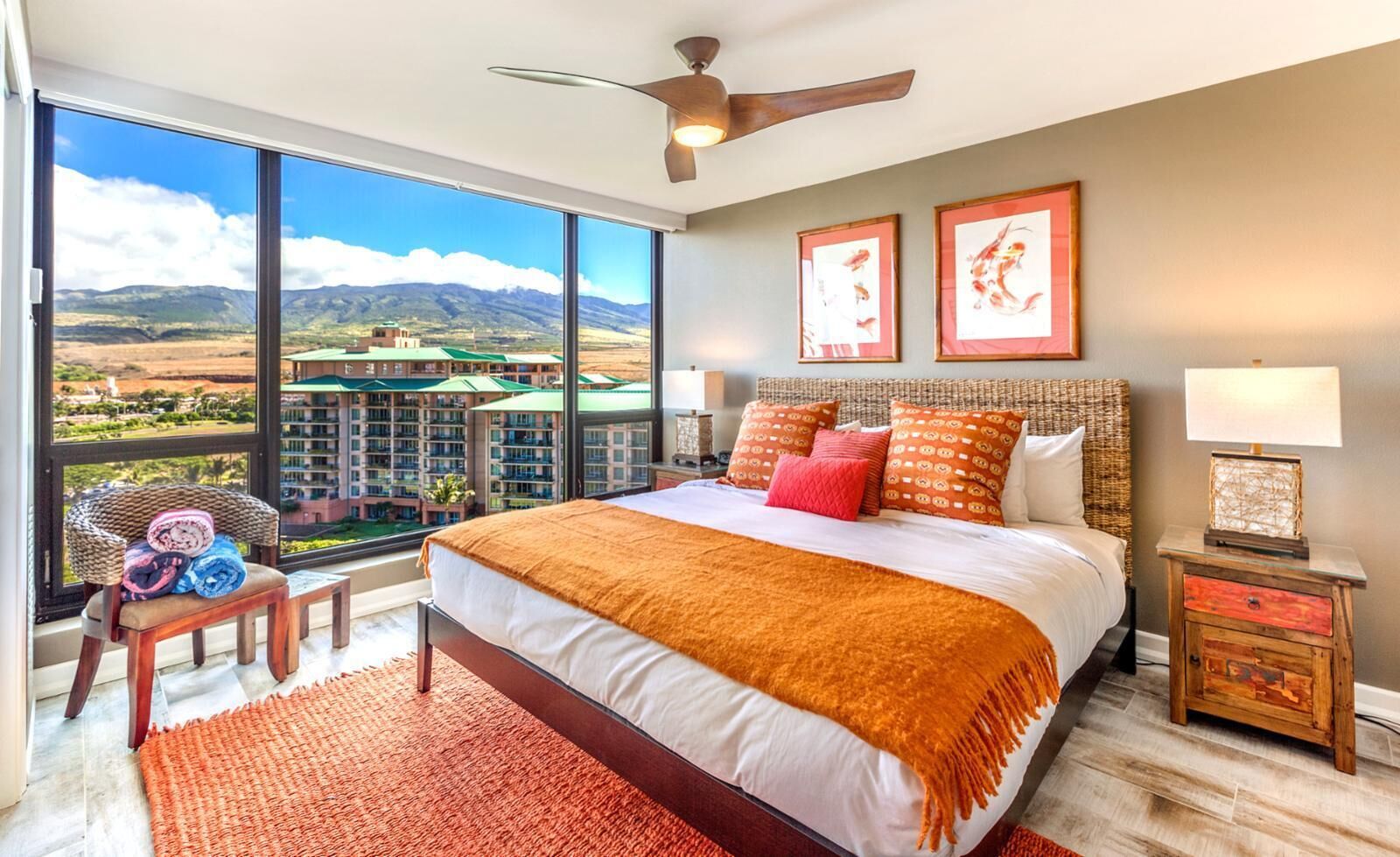Un dormitorio amplio con una cama grande, vistas a montañas y un resort, y un ventilador de techo.