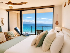 A bedroom with a large sliding glass door leading to a balcony with a view of the ocean. - Mahana Resort by KBM (Kaanapali)
