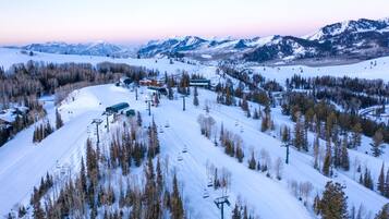 A ski resort with a chairlift, snow-covered slopes, and mountain views.