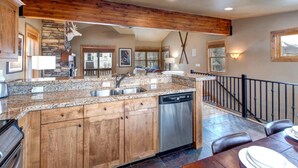 A spacious kitchen with granite countertops, wooden cabinets, and a stainless steel dishwasher. - Norfolk Escape 3 Bedrooms PNF-860 by KBM (Park City)