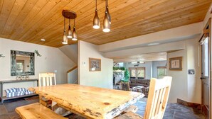 A wooden dining table with benches, a hanging light fixture, and a stone-tiled floor. - Nastar-Lowell 4 Bedrooms plus Loft PLA-1155 by KBM (Park City)