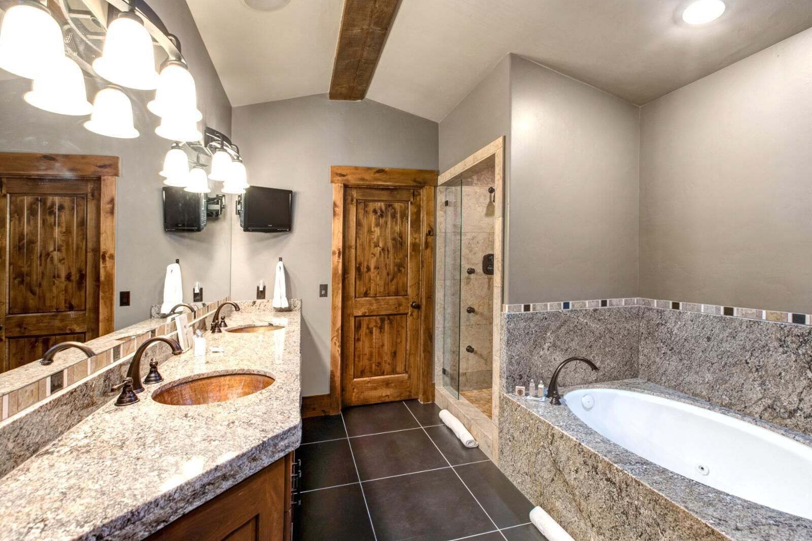 A bathroom with two sinks, a bathtub, and a shower.