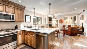 A spacious kitchen with wooden cabinets, stainless steel appliances, and a large island. - Red Pine 4 Bedrooms RPT-14T by KBM (Park City)
