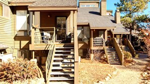 A two-story wooden house with a front porch, a staircase, and a garage. - Red Pine 4 Bedrooms RPT-14T by KBM (Park City)
