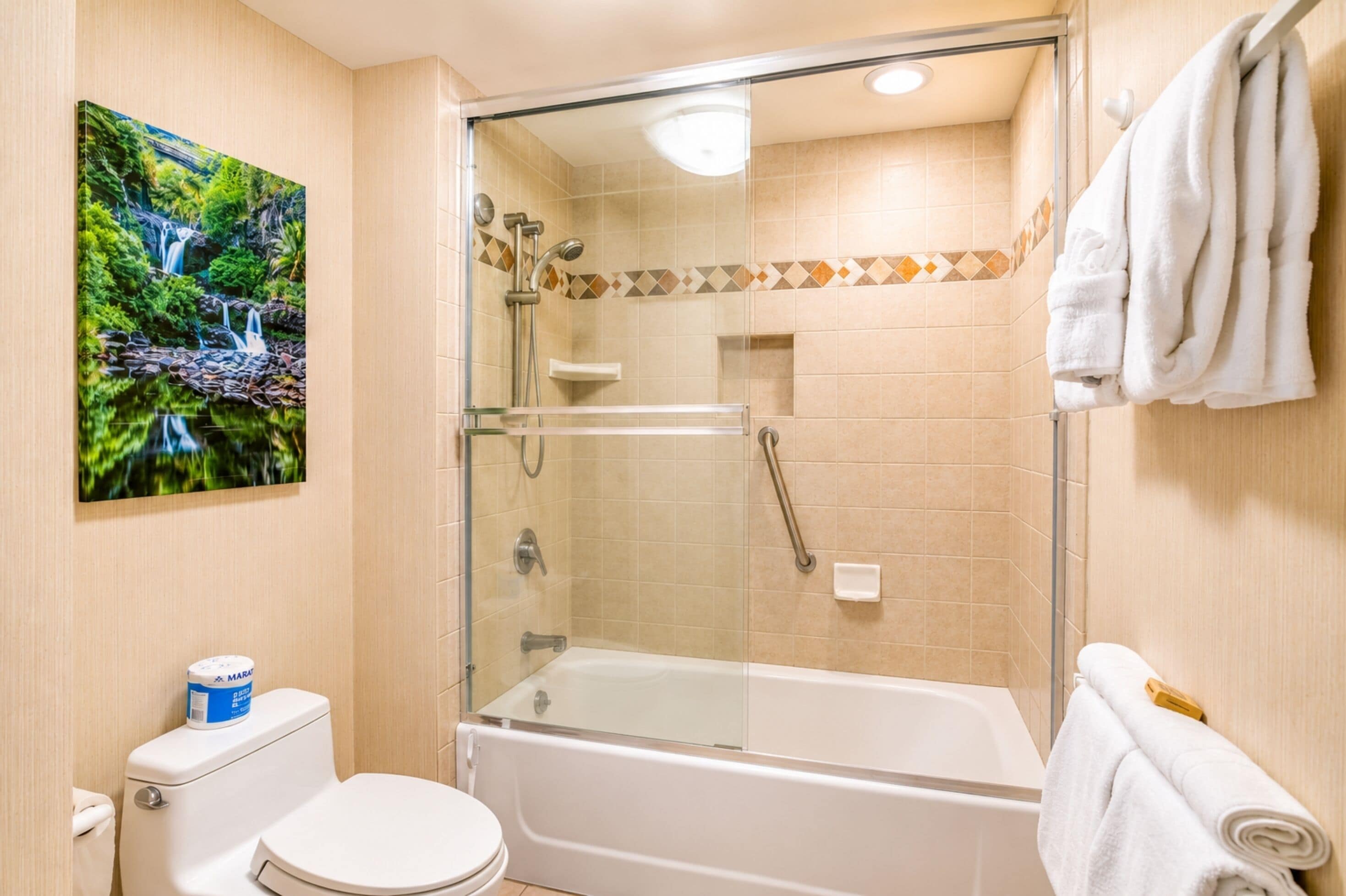 A bathroom with a glass-enclosed shower, a toilet, and a sink.