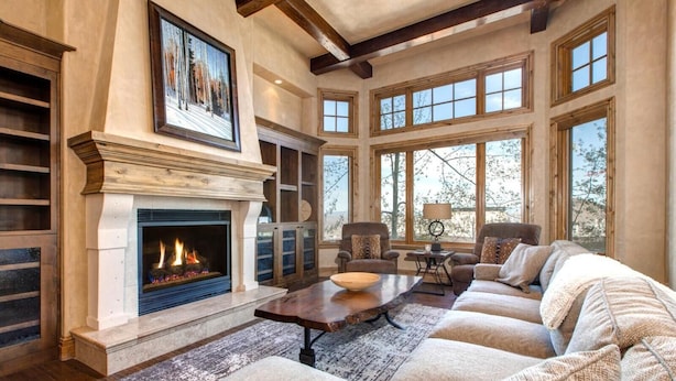 A spacious living room with a fireplace, large windows, and a cozy seating area. - Vintage on the Strand by KBM (Park City)