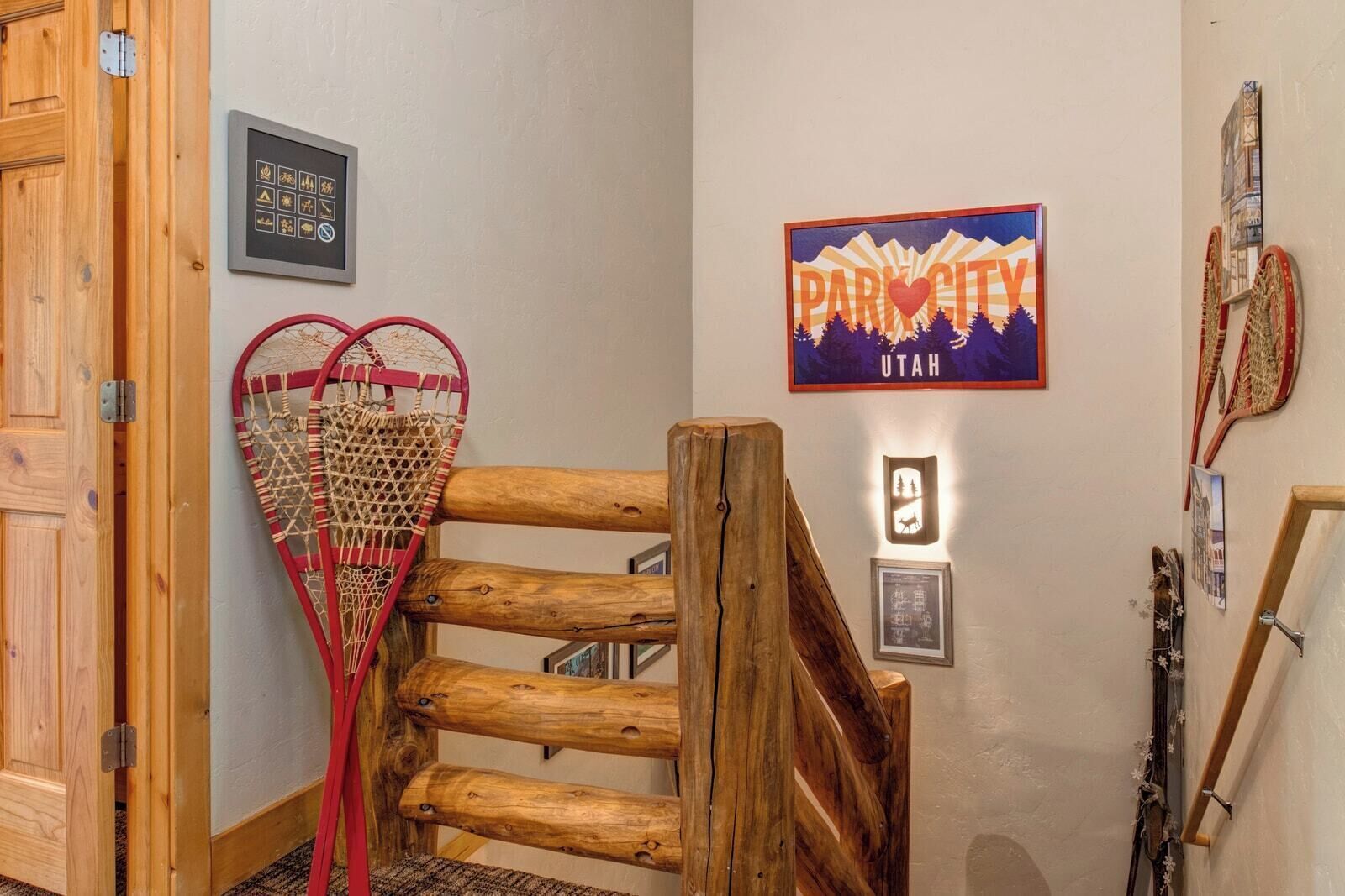 En trätrappa med ett hjärtformat, nätliknande föremål på vänster sida, en skylt med texten ”PARCITY UTAH” på väggen och en inramad bild av ett berg.