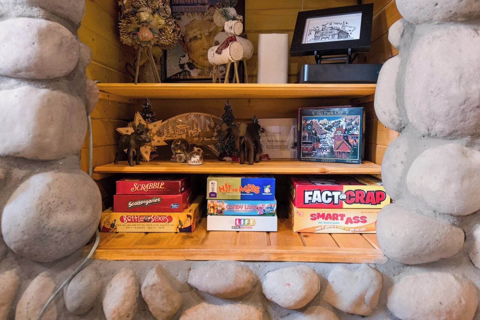 A shelf with board games and a framed map.