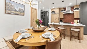 Una cocina moderna con armarios de madera, una isla central e iluminación colgante.