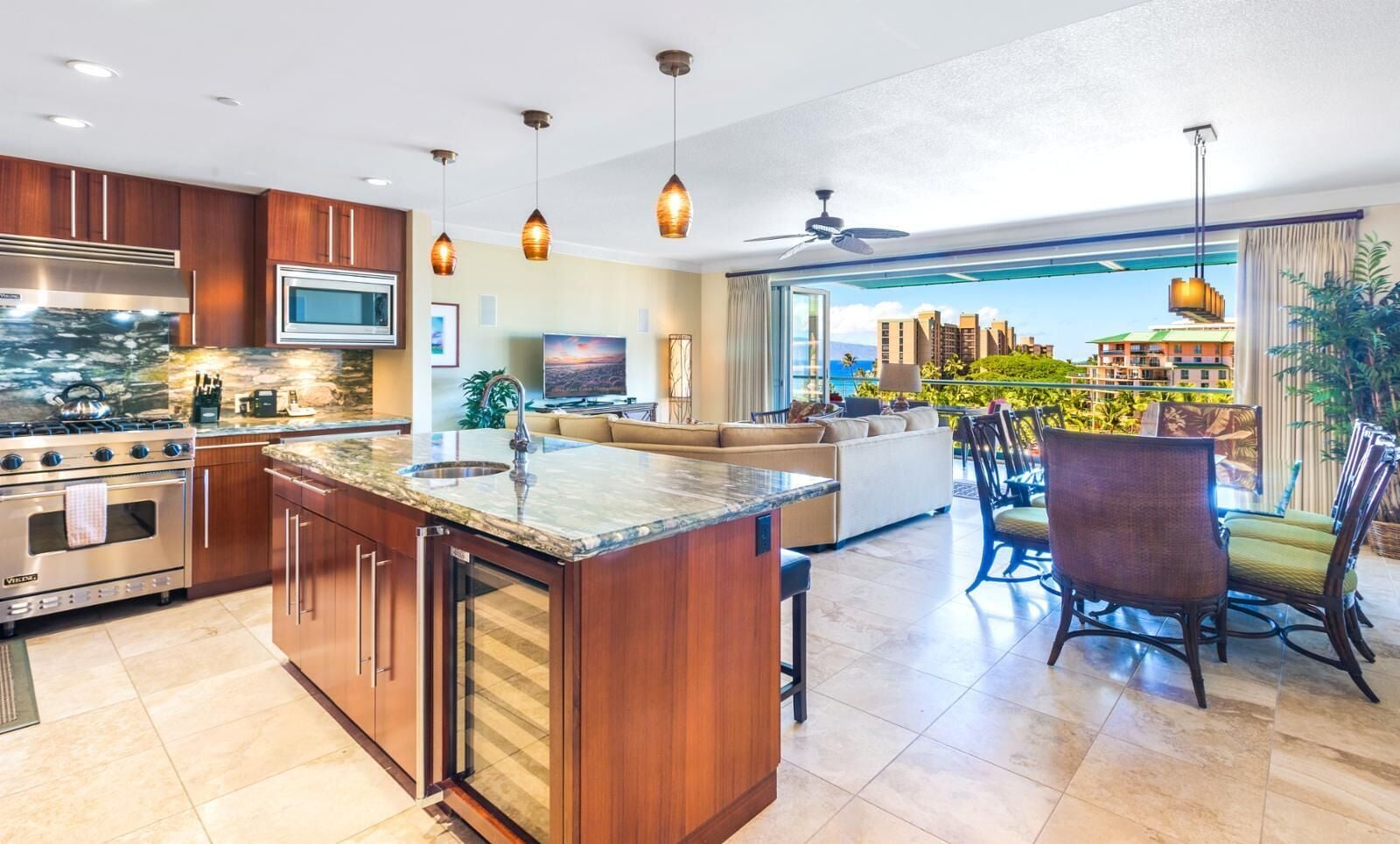 A modern kitchen with a central island, built-in oven, and a large window overlooking a cityscape.
