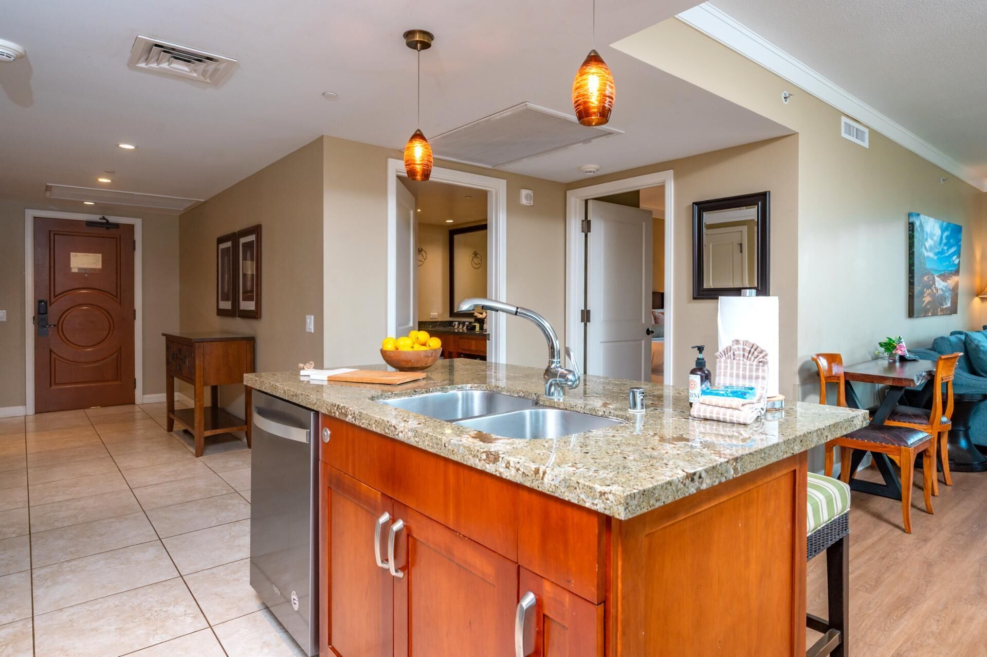 A kitchen with granite countertops, stainless steel appliances, and pendant lighting.