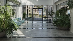 A spacious atrium with a high ceiling, large windows, and modern furnishings. - AMIRA LUXURY RESORT & SPA (Rethymno)