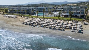 A coastal hotel with multiple swimming pools, beach umbrellas, and a view of the sea. - AMIRA LUXURY RESORT & SPA (Rethymno)