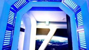 Ein futuristisches Zimmer mit Blick auf das Meer durch ein großes Fenster.
