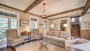 A spacious living room with a wooden ceiling, a large sofa, two armchairs, a glass coffee table, and a fireplace. - Beautiful Trillium Home Next to Waterfall! (Cashiers)