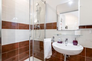 Regadera, secadora de cabello, bidet, papel de baño 