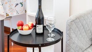 Ein Tisch mit einer Weinflasche, einem Glas und einer Obstschale.
