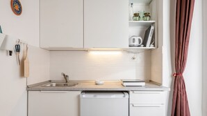 A compact kitchenette with a sink, dishwasher, and a small countertop. - GuestHost - Functional 22sqm studio apartment that can accommodate 2 people. Located on the first floor, with elevator (not suitable for disabled people), of a building in San Lorenzo neighborhood, the studio is about 15 minutes walk away from Santa Mari (Firenze)
