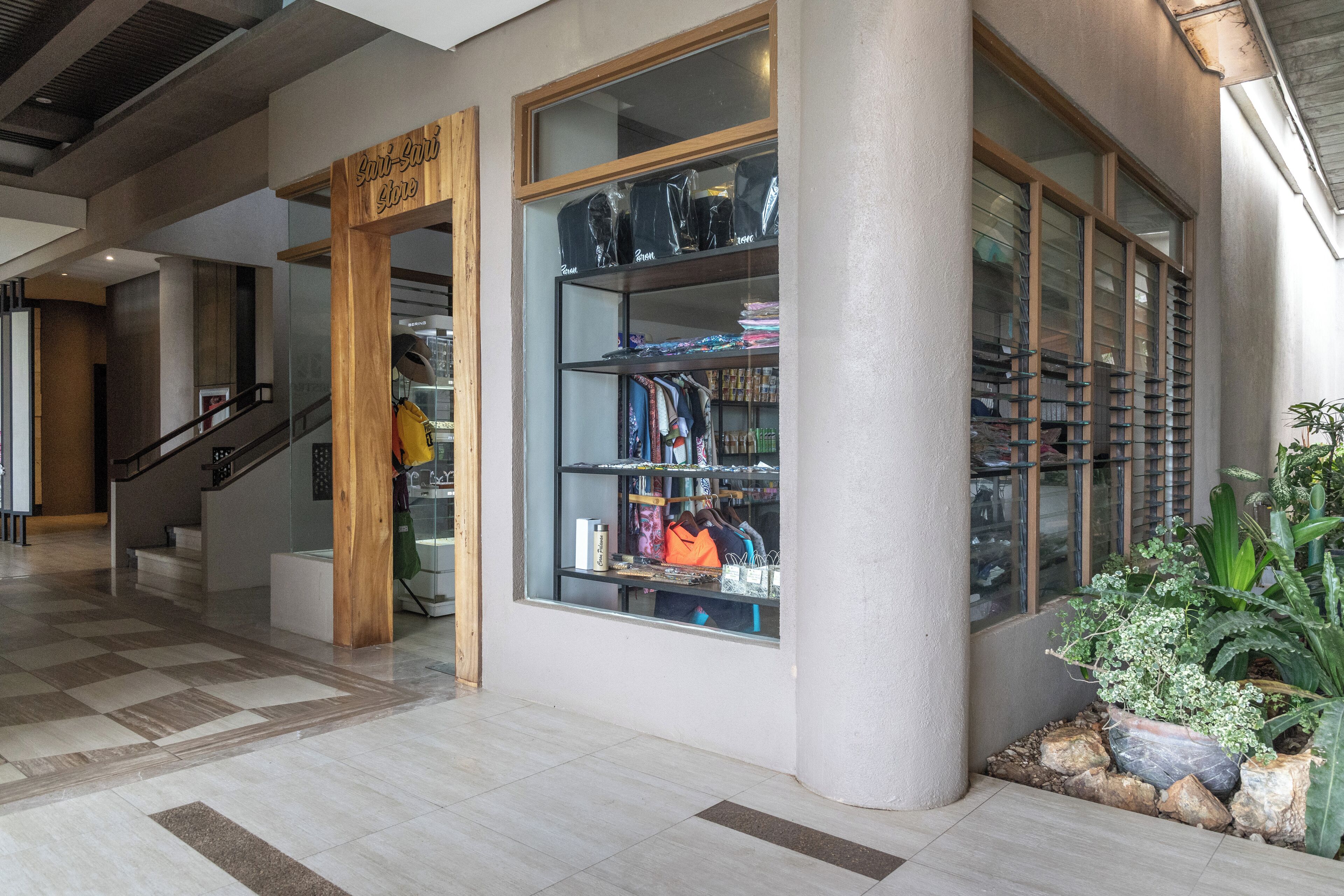 A modern interior with a staircase, a wooden sign, and a glass display case with items.