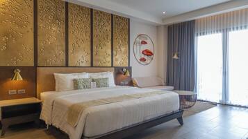 A modern hotel room with a large bed, a bedside table, a chair, and a decorative wall panel.
