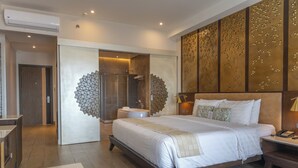 Una habitación de hotel moderna con una cama grande, zona de ducha y tocador.