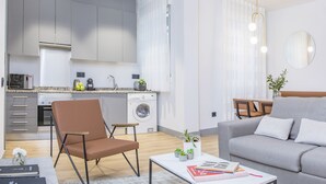 A modern apartment with a kitchen, living area, and a grey sofa. - Incredible 1 bedroom apartment at El Rastro (Madrid)