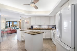 Enjoy cooking in this well-lit kitchen with a central island, refrigerator, and oven.