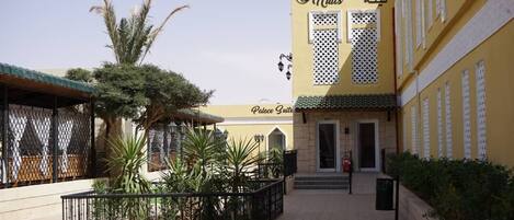 A building with a sign reading "1000" and "Nuits" in Arabic, suggesting a hotel or resort.