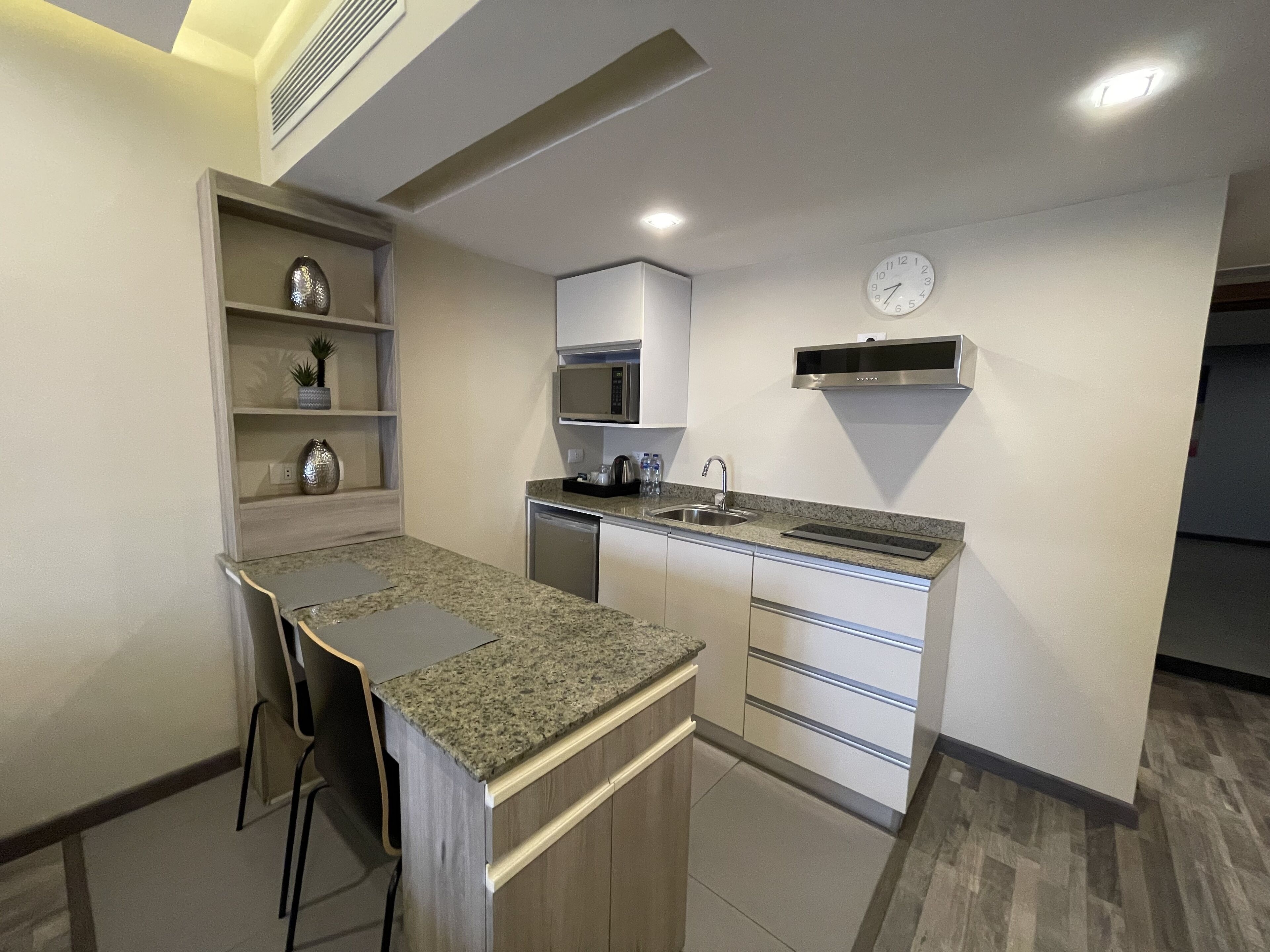 A modern kitchen with a granite countertop, stainless steel appliances, and a built-in microwave.