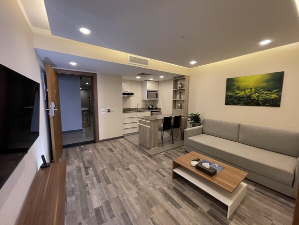 A modern living room with a sofa, coffee table, and a TV. - Ocean Blue Studios (Cairo)