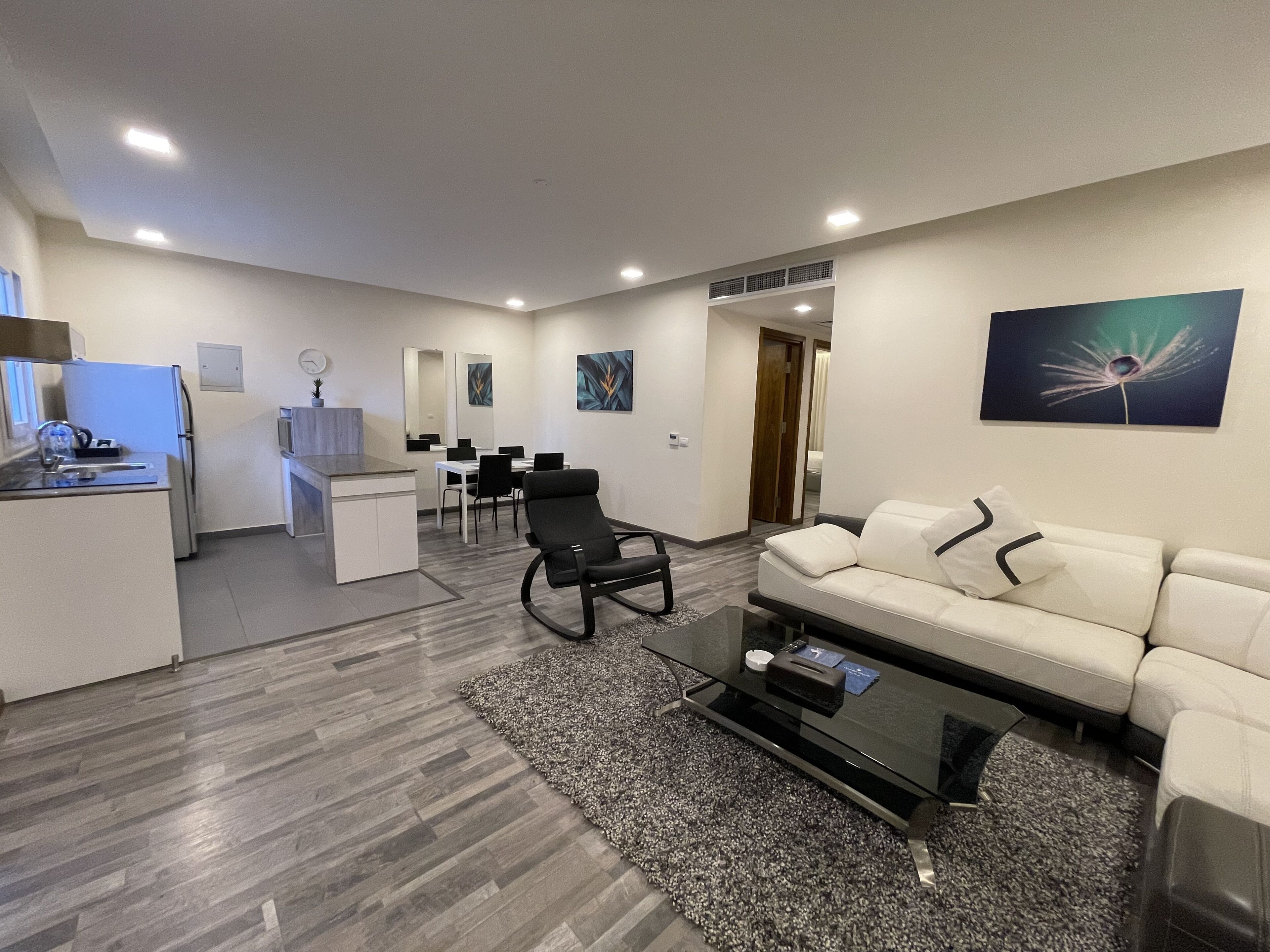 Un salon moderne comprenant un canapé, une table basse et un coin repas avec des chaises et une table.
