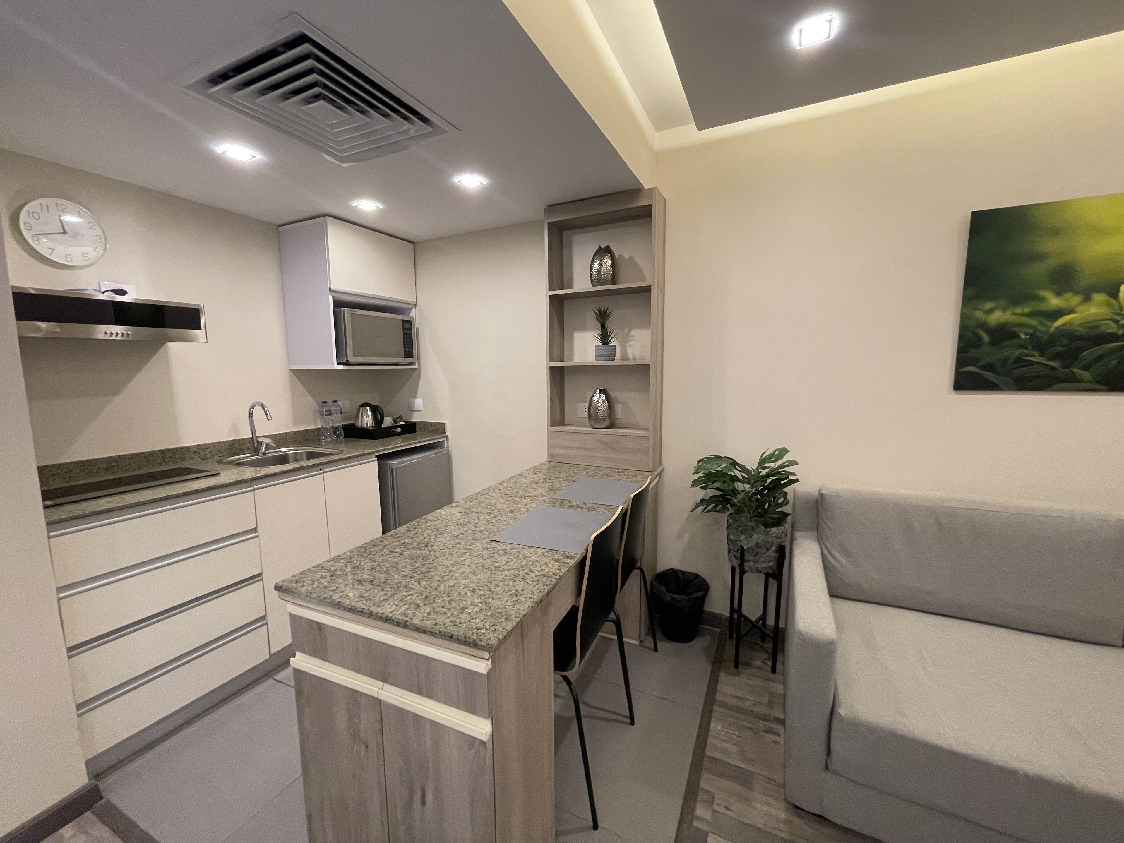 A modern kitchen with a central island, built-in appliances, and a seating area with a couch.