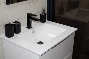 Bathroom features a sleek, rectangular sink with a single faucet and pull-down spray head.