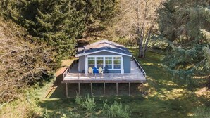 A house with a deck and two chairs.