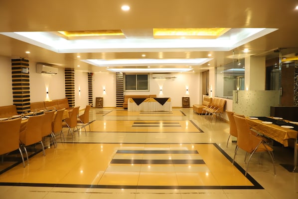 A spacious hotel lobby with a central reception desk, multiple seating areas, and a modern design featuring a reflective floor and ceiling lights. - SKG Royal Palace (Bhopal)