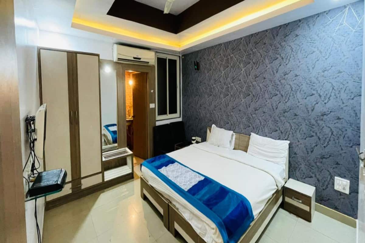 A modern bedroom with a large bed, a ceiling fan, and a textured wall.