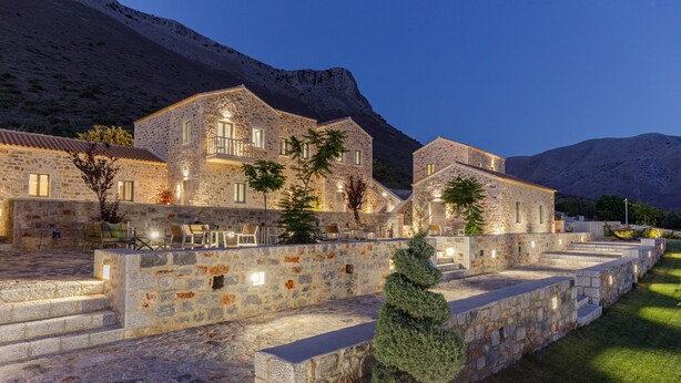 A stone building with multiple balconies and a staircase leading to a terrace. - Salvia Areopolis All-Suite Hotel (East Mani)
