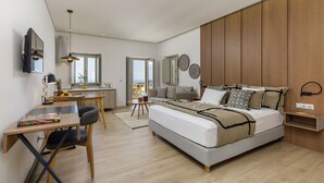 A modern bedroom with a large bed, a desk, and a sofa. - Salvia Areopolis All-Suite Hotel (East Mani)