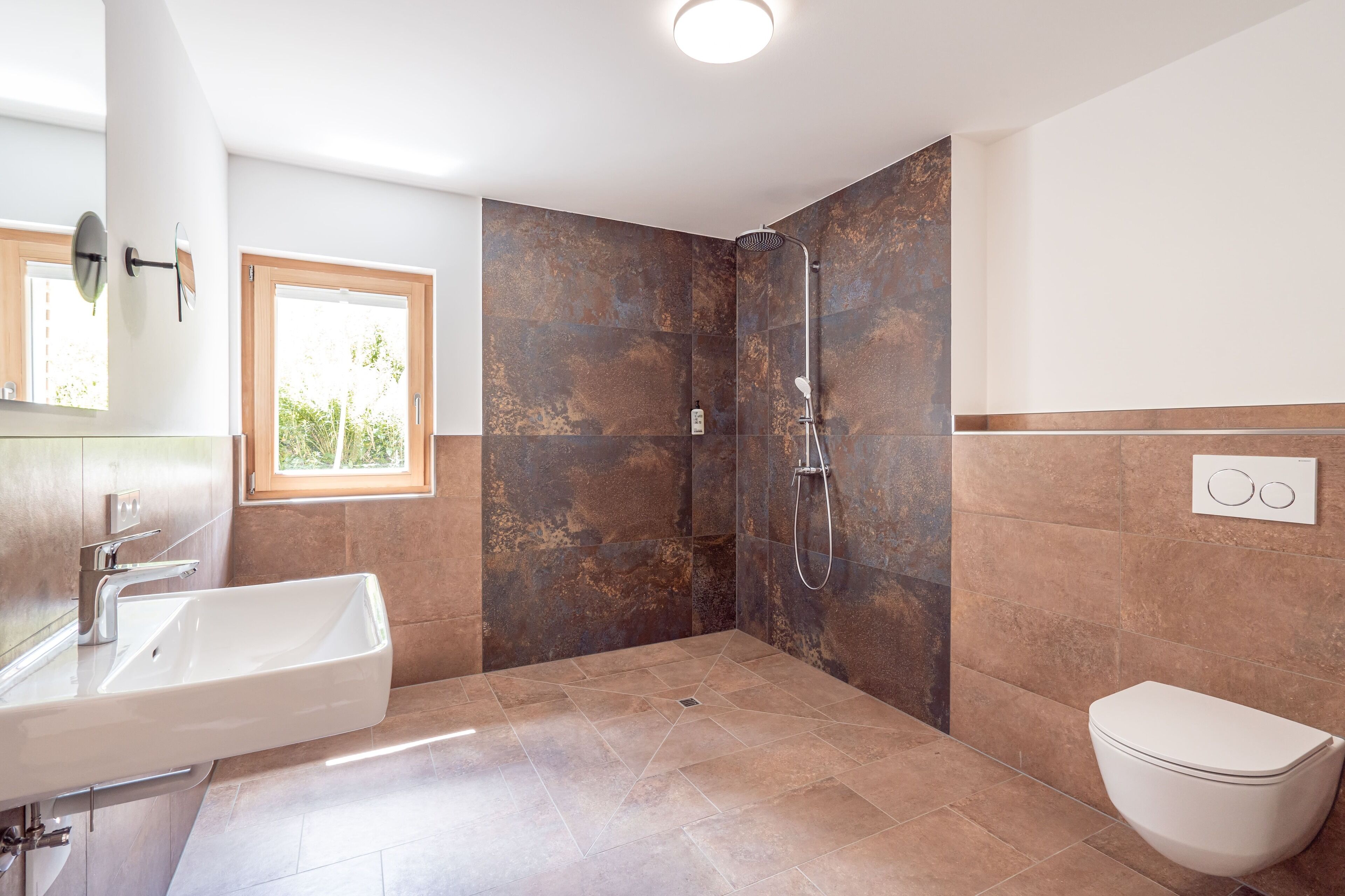 Un baño moderno con un lavabo grande, ducha e inodoro.
