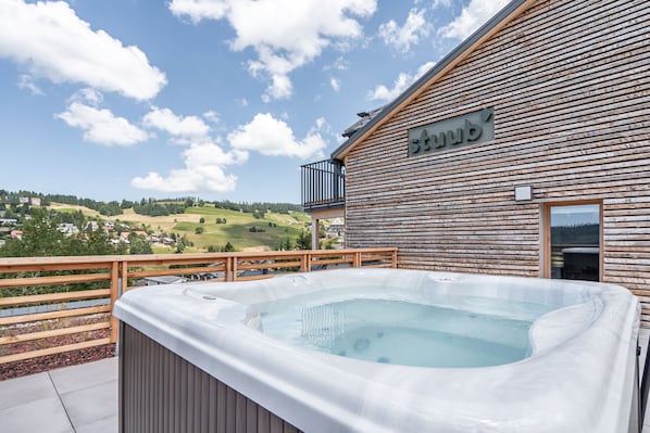 A wooden building with a hot tub and a wooden deck overlooking a scenic landscape. - stuub todtnauberg (Todtnau)
